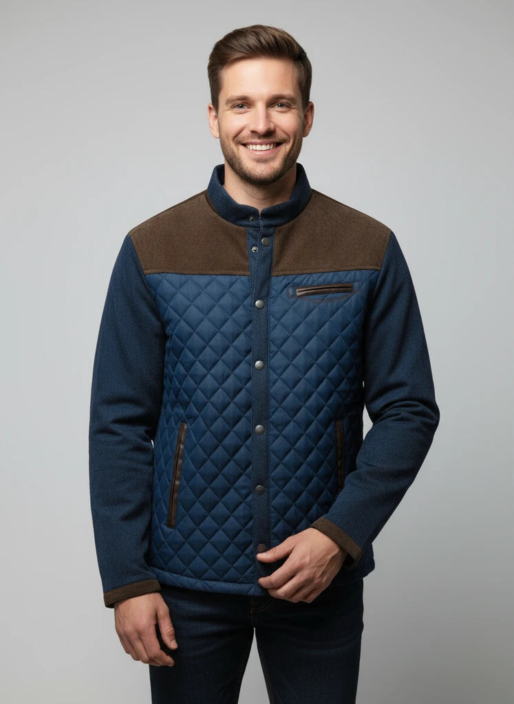 Man wearing a blue quilted jacket with brown accents on a gray background