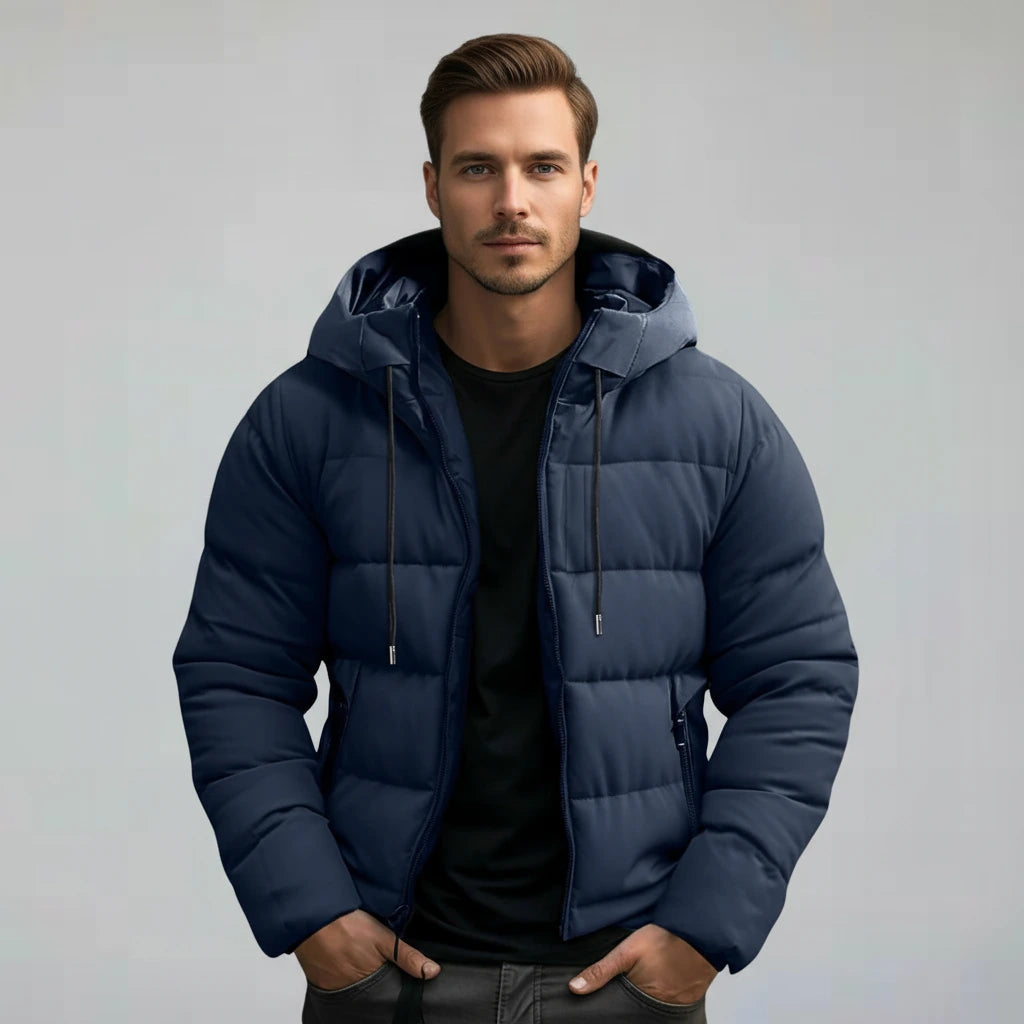 Man wearing a blue puffer jacket against a plain background