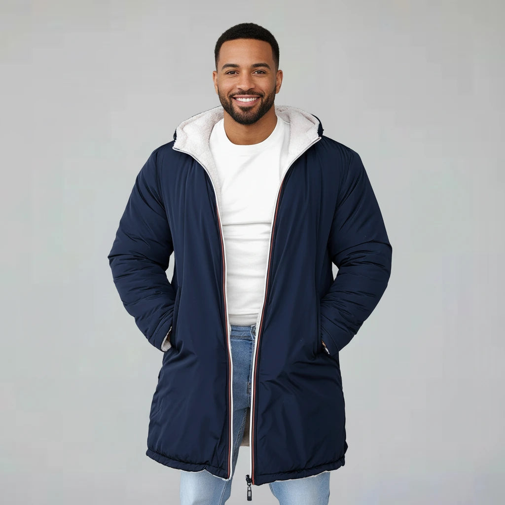 Man wearing a navy blue coat with a white hood on a gray background