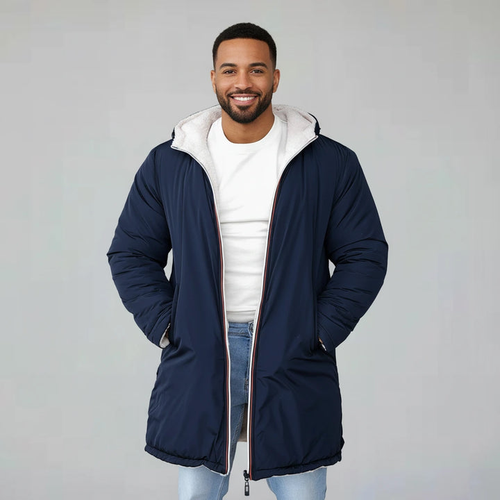 Man wearing a navy blue coat with a white hood on a gray background