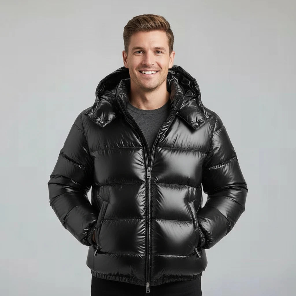 Man wearing a black puffer jacket against a gray background