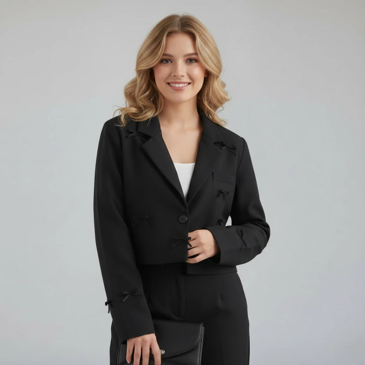 Woman wearing a black suit against a gray background